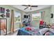 Bright bedroom with a ceiling fan, natural light, a desk area, and fun wall art at 1125 Rolling Woods Ln, Lakeland, FL 33813