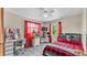 Bedroom features a modern bed with built-in lighting, a desk area, and bright red curtains at 1125 Rolling Woods Ln, Lakeland, FL 33813