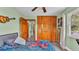 Cozy bedroom with wood-look flooring, closet with wooden doors, ceiling fan and natural light at 1125 Rolling Woods Ln, Lakeland, FL 33813