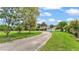 Long driveway leading to a charming two-story home surrounded by lush greenery and landscaping at 1125 Rolling Woods Ln, Lakeland, FL 33813