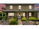 Charming two-story home at dusk with a brick and siding facade, a welcoming front porch and lush landscaping at 1125 Rolling Woods Ln, Lakeland, FL 33813