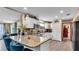 Open kitchen features white cabinets, granite countertops, and a breakfast bar with seating at 1125 Rolling Woods Ln, Lakeland, FL 33813