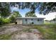 Back exterior featuring a shed, siding, grass, and a sandy lot at 124 Tyler St, Lake Wales, FL 33859