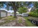 This backyard has a storage shed, a trailer, a tree, and a white fence at 124 Tyler St, Lake Wales, FL 33859