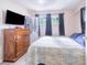 Comfortable bedroom with a large window, dresser, and TV set at 124 Tyler St, Lake Wales, FL 33859