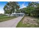 Beautiful single-story home with a long driveway, a covered front porch, and mature trees at 124 Tyler St, Lake Wales, FL 33859