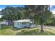 Beautiful yard with mature trees and green lawn highlighting cozy, single-story home with metal roof at 124 Tyler St, Lake Wales, FL 33859