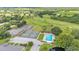 An aerial view of a community featuring tennis courts, a pool, green spaces, and a golf course at 13 Enclave Dr, Winter Haven, FL 33884