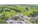A high angle picture of the clubhouse, a golf course and green spaces surrounding the community at 13 Enclave Dr, Winter Haven, FL 33884