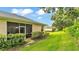 A home's backyard featuring a lawn, screened patio, and partial view of the building at 13 Enclave Dr, Winter Haven, FL 33884