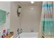 Clean bathroom featuring tile walls and tub/shower with colorful shower curtain at 13 Enclave Dr, Winter Haven, FL 33884