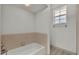 A bathtub and shower in a bathroom with beige tile and a small window at 13 Enclave Dr, Winter Haven, FL 33884