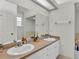 Bathroom vanity with double sinks, spacious mirror, and white cabinets at 13 Enclave Dr, Winter Haven, FL 33884