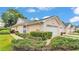 Charming home featuring a two-car garage, manicured lawn, and lush landscaping at 13 Enclave Dr, Winter Haven, FL 33884