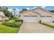 Charming home featuring a white garage door, complemented by lush landscaping and a well-maintained driveway at 13 Enclave Dr, Winter Haven, FL 33884