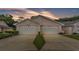 Beautiful home exterior featuring two white garage doors under a stunning sunset sky at 13 Enclave Dr, Winter Haven, FL 33884