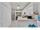 Bright kitchen with white cabinets and stainless appliances, adjacent to laundry and dining at 13 Enclave Dr, Winter Haven, FL 33884