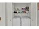 Convenient laundry area with appliances and shelving for storage, easily accessible at 13 Enclave Dr, Winter Haven, FL 33884