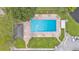 Aerial view of a pool with lounge chairs, surrounded by trees, landscaping, and parking spaces at 13 Enclave Dr, Winter Haven, FL 33884