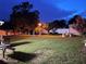 Backyard at night with a fountain, benches, flowers, and well-kept grass at 1366 Merrimack Pl, Davenport, FL 33837
