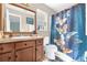 Well-lit bathroom featuring a vanity with storage, a toilet, and a shower with a butterfly-themed curtain at 1366 Merrimack Pl, Davenport, FL 33837