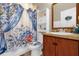 Well-equipped bathroom with a blue floral shower curtain and a classic vanity and mirror at 1366 Merrimack Pl, Davenport, FL 33837