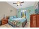 Bright bedroom with a floral bedspread, ceiling fan, and a window that provides natural light at 1366 Merrimack Pl, Davenport, FL 33837