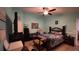Bedroom with light blue walls, tile floor, ceiling fan, and a bed with a dark blue and gold floral cover at 1366 Merrimack Pl, Davenport, FL 33837
