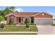 Charming single-story home featuring a well-manicured lawn and a two-car garage at 1366 Merrimack Pl, Davenport, FL 33837