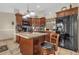 Well-lit kitchen features an island with granite countertop, dark cabinetry, and stainless steel appliances at 1366 Merrimack Pl, Davenport, FL 33837