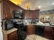 Functional kitchen featuring dark wood cabinets, granite countertops, and modern black appliances at 1366 Merrimack Pl, Davenport, FL 33837