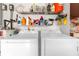 Functional laundry area with a washer, dryer, and shelving for organized storage solutions at 1366 Merrimack Pl, Davenport, FL 33837