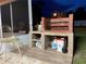 Outdoor brick grill with tiled base, along with a clear chair and view of the backyard at 1366 Merrimack Pl, Davenport, FL 33837