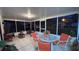 Screened patio with a glass table, four orange chairs, and various plants around the edges of the room at 1366 Merrimack Pl, Davenport, FL 33837