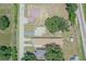 An aerial view shows several homes, large trees, and train tracks nearby at 2125 Hillcrest Rd, Auburndale, FL 33823