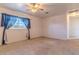 Neutral bedroom with a ceiling fan, neutral carpet, and a window with blue curtains at 2125 Hillcrest Rd, Auburndale, FL 33823