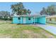 Charming turquoise home featuring a carport and well-maintained front yard and minimalist landscaping at 2125 Hillcrest Rd, Auburndale, FL 33823
