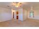 Open-concept living room with neutral carpet, ceiling fan, and kitchen view at 2125 Hillcrest Rd, Auburndale, FL 33823