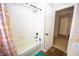 Clean bathroom showcasing a tub/shower combo with shower curtain and a white tiled surround at 2169 Rose Blvd, Winter Haven, FL 33881