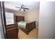 Bedroom features a ceiling fan, carpeted floors, and a stylish dark wood sleigh bed and matching dresser at 2169 Rose Blvd, Winter Haven, FL 33881