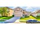 Tan two-story home featuring a two-car garage and a green front lawn at 2169 Rose Blvd, Winter Haven, FL 33881