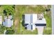 An aerial view shows a modern home with a light-colored metal roof and solar panels on a spacious lawn at 2218 Melbourne Ave, Haines City, FL 33844