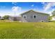 Spacious backyard features green grass, a gray home exterior, and a detached garage at 2218 Melbourne Ave, Haines City, FL 33844