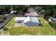 An exterior view showcases a home with metal roof and solar panels, surrounded by a well-kept lawn at 2218 Melbourne Ave, Haines City, FL 33844