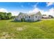 Landscaped yard highlights this charming gray home with ample green space and mature landscaping at 2218 Melbourne Ave, Haines City, FL 33844