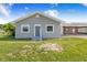 Gray home with solar panels, gray siding, and a charming front entrance and ample parking space at 2218 Melbourne Ave, Haines City, FL 33844