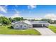 Inviting single-story home featuring gray siding, solar panels, metal roof and large carport at 2218 Melbourne Ave, Haines City, FL 33844