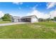 The home features gray siding, a metal roof, solar panels, and a spacious carport area at 2218 Melbourne Ave, Haines City, FL 33844