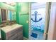 Colorful bathroom featuring green walls, a vanity with wood grain cabinet, and themed decor at 237 Manatee Rd, Winter Haven, FL 33884