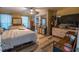 This bedroom features wood-look floors, neutral paint, a ceiling fan, and large windows at 237 Manatee Rd, Winter Haven, FL 33884